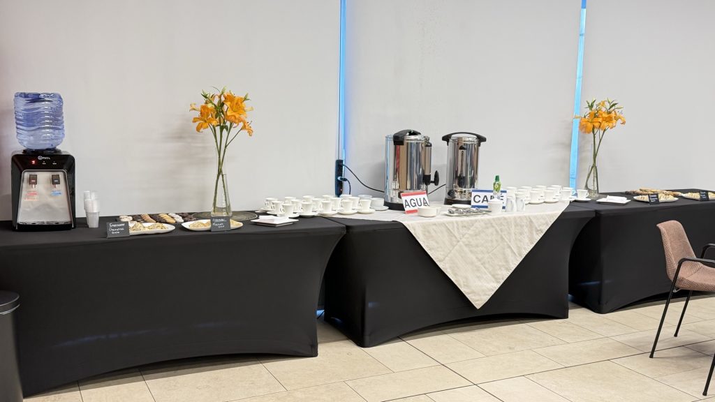 Mesa de coffee break del taller con café, agua y empanadas para los participantes.